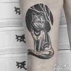 大腿部位一只扭头坐着的黑色狐狸纹身图片